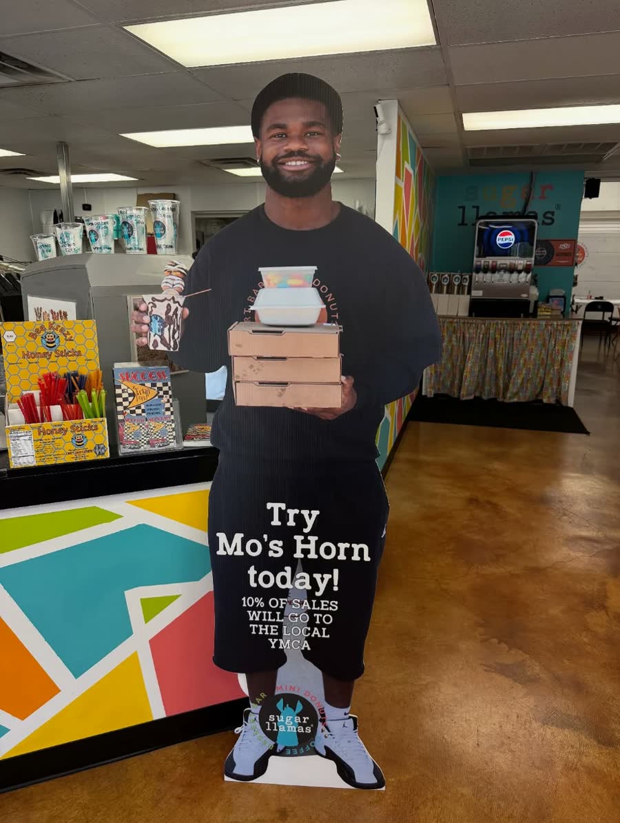 Life-size cutout of Maurion Horn at Sugar Llamas promoting Mo's Horn, with 10% of sales going to the local YMCA