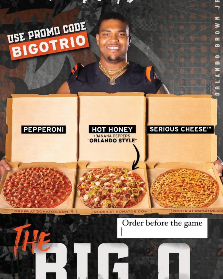 Orlando Brown Jr. holding three Donatos pizzas for The Big O Trio promotion