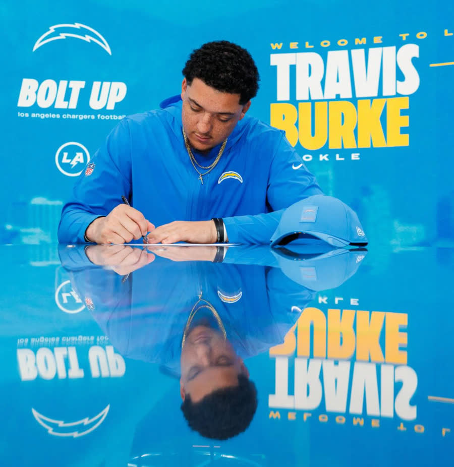 Travis Burke signing his Los Angeles Chargers contract